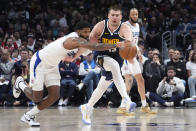 Los Angeles Clippers forward Paul George, left, and Denver Nuggets center Nikola Jokic go after a loose ball during the second half of an NBA basketball game Thursday, April 4, 2024, in Los Angeles. (AP Photo/Mark J. Terrill)