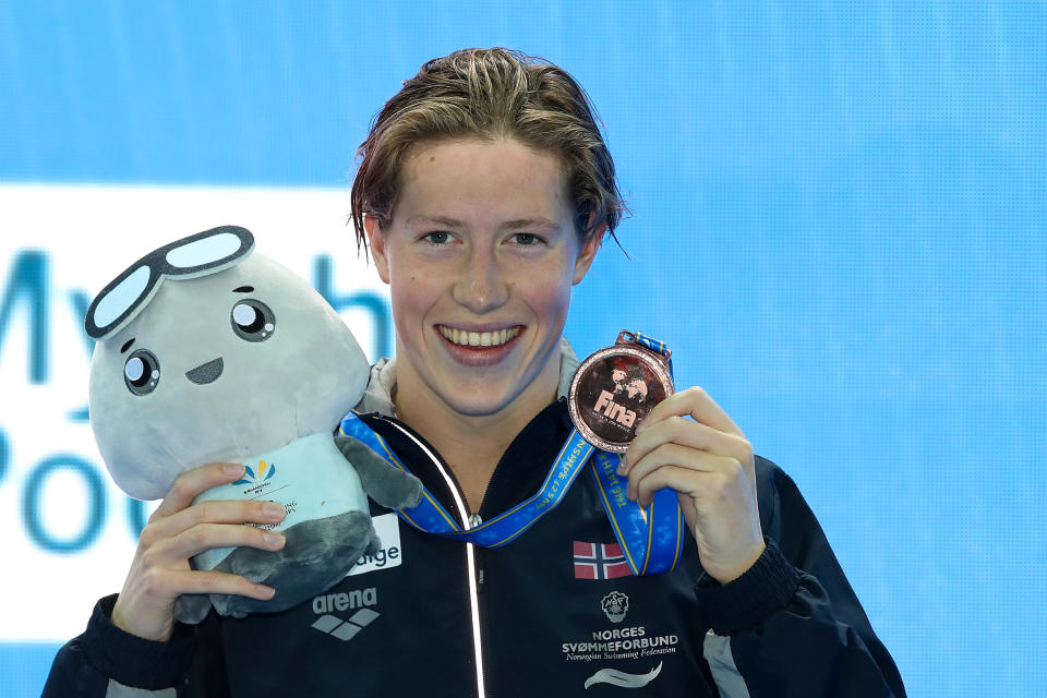 Bronze medalist Henrik Christiansen of Norway poses with his medal in the air.