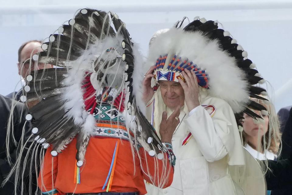 Pope Francis puts on an Indigenous headdress during a meeting with Indigenous communities in Maskwacis, near Edmonton, on July 25, 2022. (AP Photo/Gregorio Borgia)