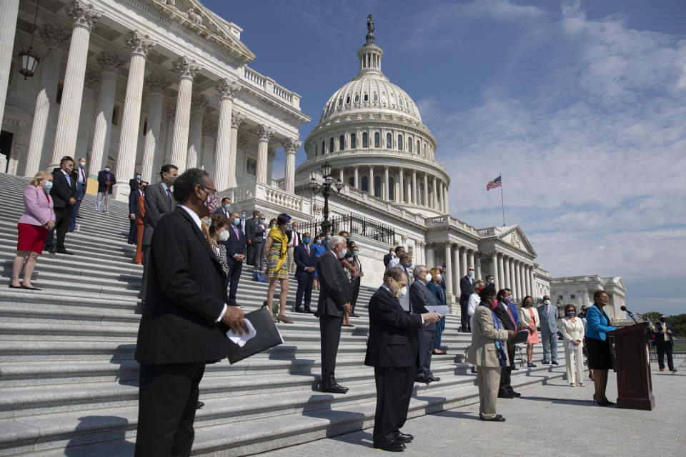 Rep. Karen Bass, D-Calif., joined by House Speaker Nancy Pelosi of Calif., and other House Democrats spaced for social distancing, speaks during a news conference on the House East Front Steps on Capitol Hill in Washington, Thursday, June 25, 2020, ahead of the House vote on the George Floyd Justice in Policing Act of 2020. (AP Photo/Carolyn Kaster)