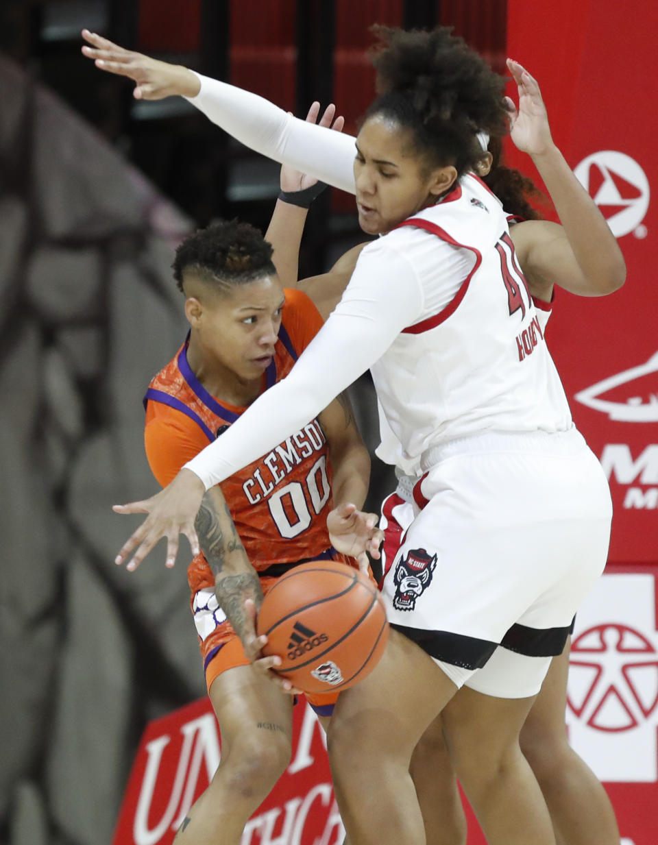Clemson's Delicia Washington (00) passes around the pressure by North Carolina State's Camille Hobby (41) during the first half of an NCAA college basketball game at Reynolds Coliseum in Raleigh, N.C., Thursday, Feb. 11, 2021. (Ethan Hyman/The News & Observer via AP)