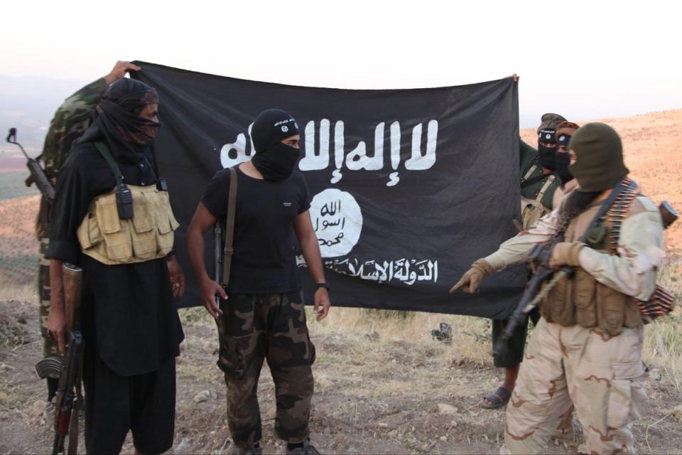 ISIS fighters holding the Al-Qaeda flag with ‘Islamic State of Iraq and the Levant’ written on it. ISIS-K are an affiliate of the group (Alamy)