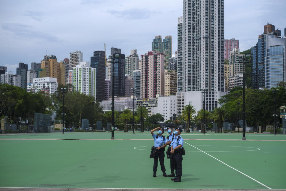 2021年6月4日，香港維多利亞公園，幾名警員駐守。當年是《港區國安法》實施後首個「六四」，支聯會原本打算申請維園燭光悼念晚會，但警方指考慮到疫情及「限聚令」，不批准有關申請。六四當日，當局出動大批警力封鎖維園草坪、足球場等範圍。（Justin Chin/Bloomberg via Getty Images） 