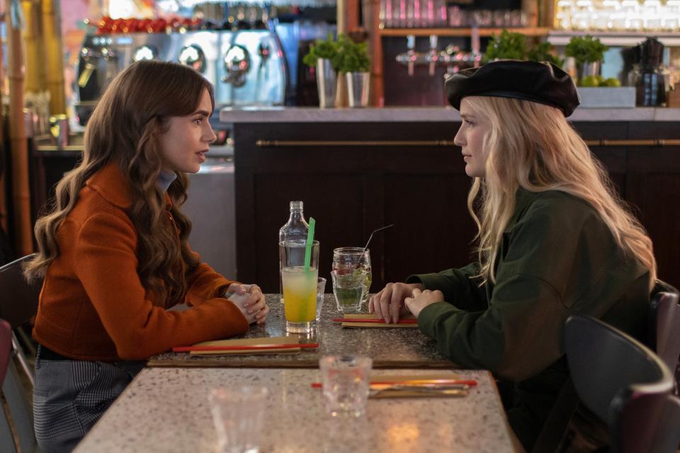 Emily (Lily Collins) and Camille (Camille Razat) in Emily in Paris, not talking about how Emily's harboring feelings for Camille's boyfriend