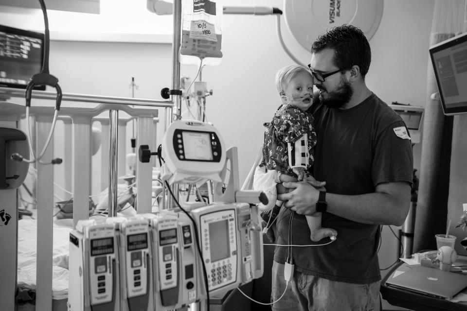 Jason Carberry holds his son Rohen as he coughs and fusses in the pediatric intensive care unit. Rohen was hospitalized with RSV.