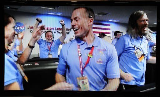 NASA Television shows the crew in the Mission Control room at the Mars Science Laboratory errupting in celebration as a successful landing on the Red Planet is confirmed on August 5, 2012, in Pasadena, California