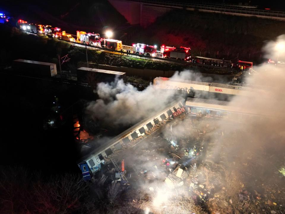 2月28日深夜希臘發生火車相撞事故，部分車廂出軌，前兩節車廂還起火燃燒。（AP）