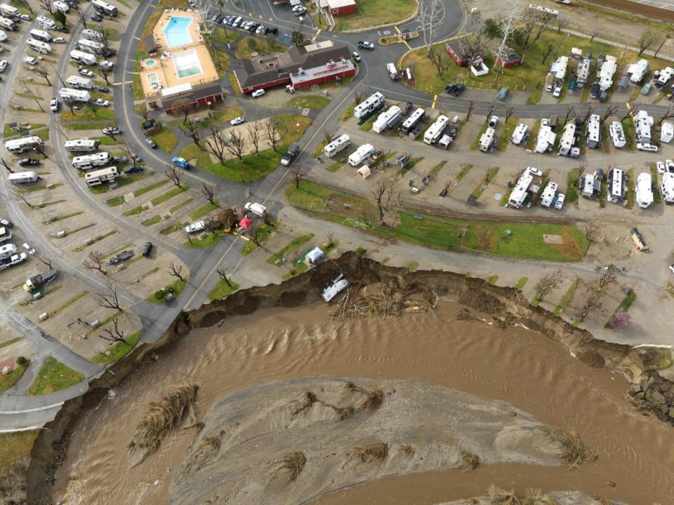 A recreational vehicle lies at the bottom of a cliff.