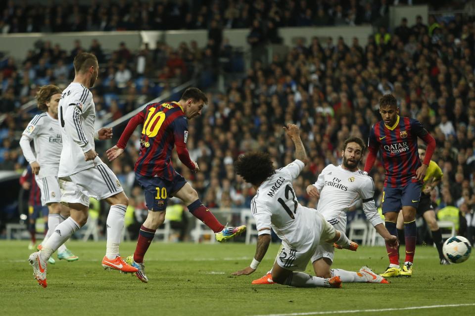 Barcelona's Lionel Messi from Argentina, centre left, scores his goal during a Spanish La Liga soccer match between Real Madrid and FC Barcelona at the Santiago Bernabeu stadium in Madrid, Spain, Sunday, March 23, 2014. (AP Photo/Andres Kudacki)