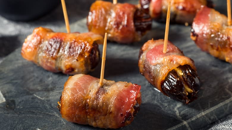 Devils on horseback bacon and dates with cocktail sticks