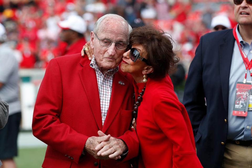Former head Georgia football coach and athletic director Vince Dooley, left, gets a kiss from his wIfe Barbara during a ceremony to name the field at Sanford Stadium in his honor before an NCAA college football game against the Murray State, Saturday, Sept. 7, 2019, in Athens, Ga. (AP Photo/John Bazemore)