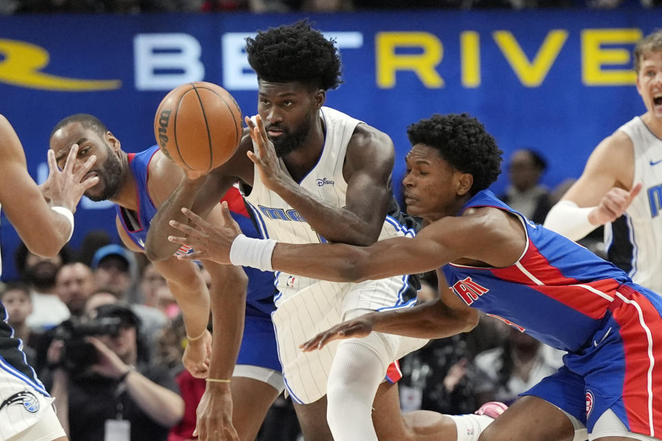 Orlando Magic forward Jonathan Isaac (1) passes the ball as Detroit Pistons forward Ausar Thompson (9) reaches in during the first half of an NBA basketball game, Sunday, Feb. 4, 2024, in Detroit. (AP Photo/Carlos Osorio)