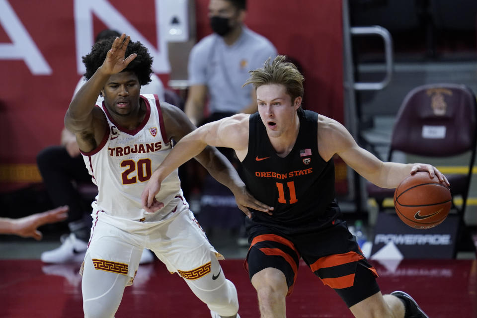 Southern California guard Ethan Anderson (20) defends against Oregon State guard Zach Reichle (11) during the first half of an NCAA college basketball game Thursday, Jan. 28, 2021, in Los Angeles. (AP Photo/Ashley Landis)