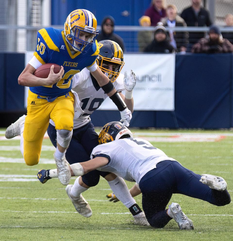 Marion’s Tate Hess hurdles the tackle attempt of Kirtland’s Will Sayle in the Division VI state final, Saturday, Dec. 3, 2022, at Tom Benson Hall of Fame Stadium.