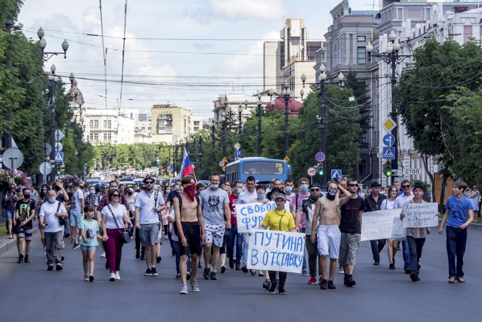 People hold posters that read: "Freedom for Sergei Furgal" and "Putin to Resign!", during an unsanctioned protest in support of Sergei Furgal, the governor of the Khabarovsk region, in Khabarovsk, 6100 kilometers (3800 miles) east of Moscow, Russia, Sunday, July 12, 2020. Sergei Furgal was arrested Thursday and flown to Moscow where he was interrogated and ordered held in jail for two months. Russia’s main criminal investigation body says he is suspected of involvement in several murders of businessmen in 2004 and 2005, before his political career began. (AP Photo/Igor Volkov)