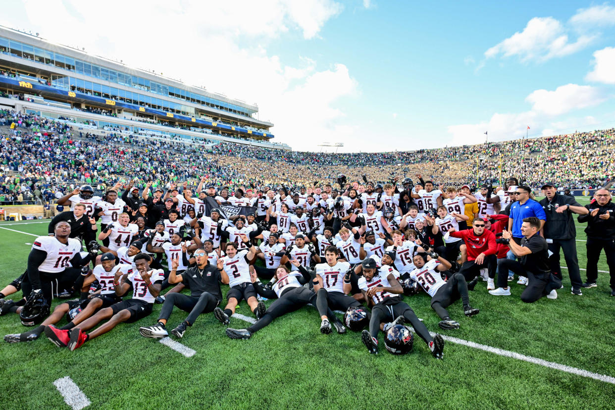 Northern Illinois Huskies pose for photos after defeating the Notre Dame Fighting Irish 16-14 at Notre Dame Stadium. (Matt Cashore-Imagn Images)