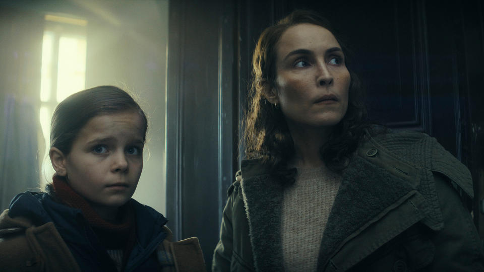 A young girl and her mother both look apprehensive as they look around the room.