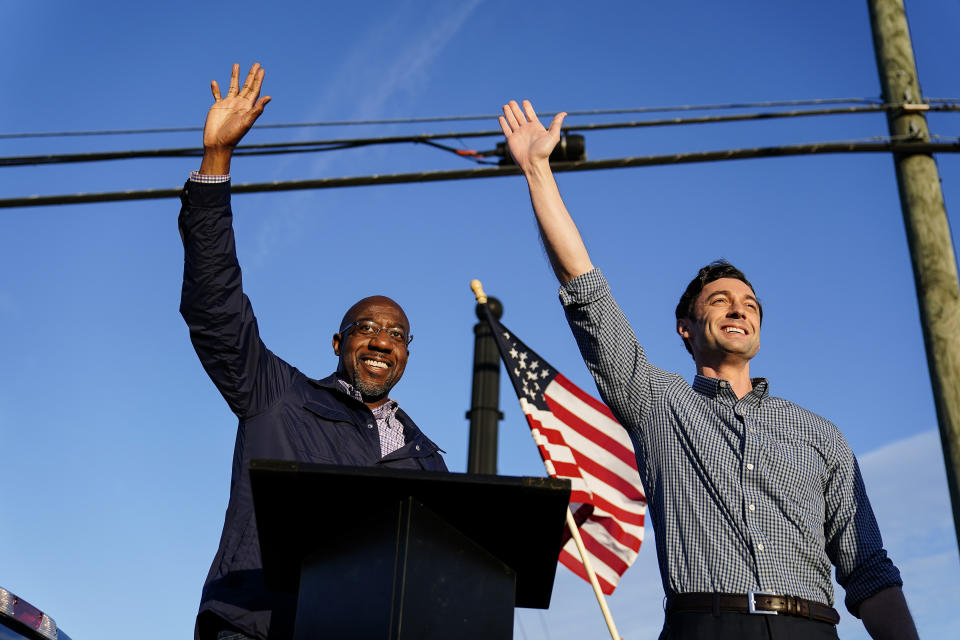 FILE - In this Nov. 15, 2020, file photo Georgia Democratic candidates for U.S. Senate Raphael Warnock, left, and Jon Ossoff, right, gesture toward a crowd during a campaign rally in Marietta, Ga. (AP Photo/Brynn Anderson, File)