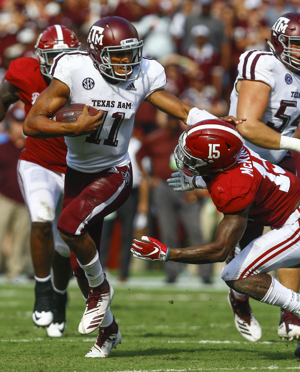 Texas A&M quarterback Kellen Mond (11) stiff arms Alabama defensive back Xavier McKinney (15) as he carries for a first down during the first half of an NCAA college football game, Saturday, Sept. 22, 2018, in Tuscaloosa, Ala. (AP Photo/Butch Dill)