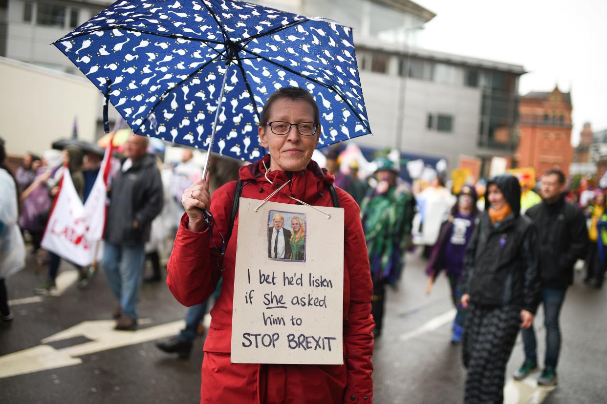 A demonstrator wears a placard with a picture of Britain's Prime Minister Boris Johnson and US businesswoman Jennifer Arcuri on it as she joins a march during a protest to coincide with the Conservative Party's annual conference, in central Manchester on September 29, 2019, organised by The People's Assembly Against Austerity. - Embattled British Prime Minister Boris Johnson gathered his Conservative party Sunday for what could be its final conference before an election, promising to "get Brexit done". Despite a string of parliamentary setbacks and a defeat in the Supreme Court, Johnson insists he will take Britain out of the European Union next month, with or without a deal with Brussels. (Photo by Oli SCARFF / AFP)        (Photo credit should read OLI SCARFF/AFP/Getty Images)