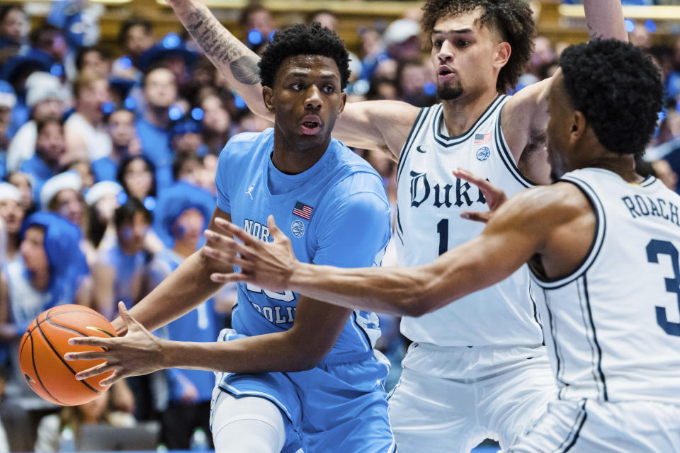 North Carolina forward Jalen Washington, left, looks to pass the ball while guarded by Duke center Dereck Lively II (1) and guard Jeremy Roach (3) in the first half of an NCAA college basketball game on Saturday, Feb. 4, 2023, in Durham, N.C. (AP Photo/Jacob Kupferman)