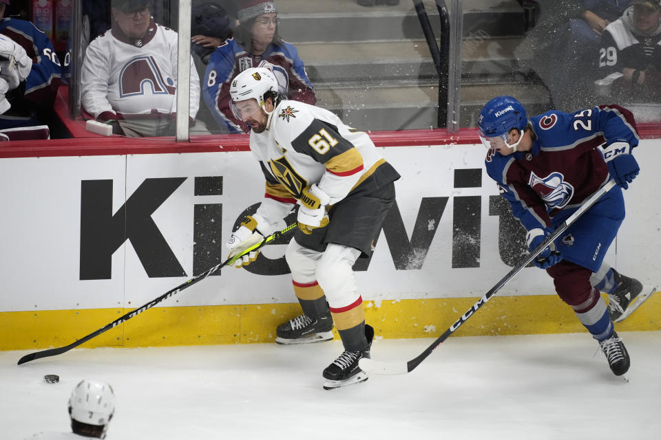 Vegas Golden Knights right wing Mark Stone, left, looks to pass the puck as Colorado Avalanche right wing Logan O'Connor defends during the third period of an NHL hockey game Wednesday, Jan. 10, 2024, in Denver. (AP Photo/David Zalubowski)