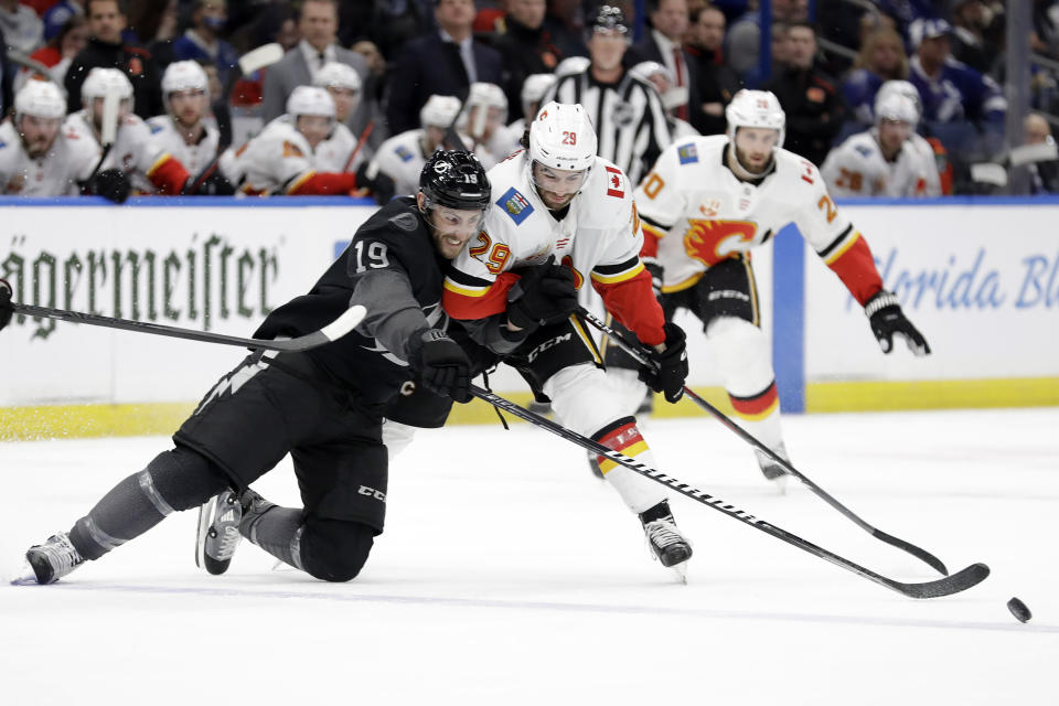 Tampa Bay Lightning center Barclay Goodrow (19) and Calgary Flames center Dillon Dube (29) battle for control of the puck during the second period of an NHL hockey game Saturday, Feb. 29, 2020, in Tampa, Fla. (AP Photo/Chris O'Meara)