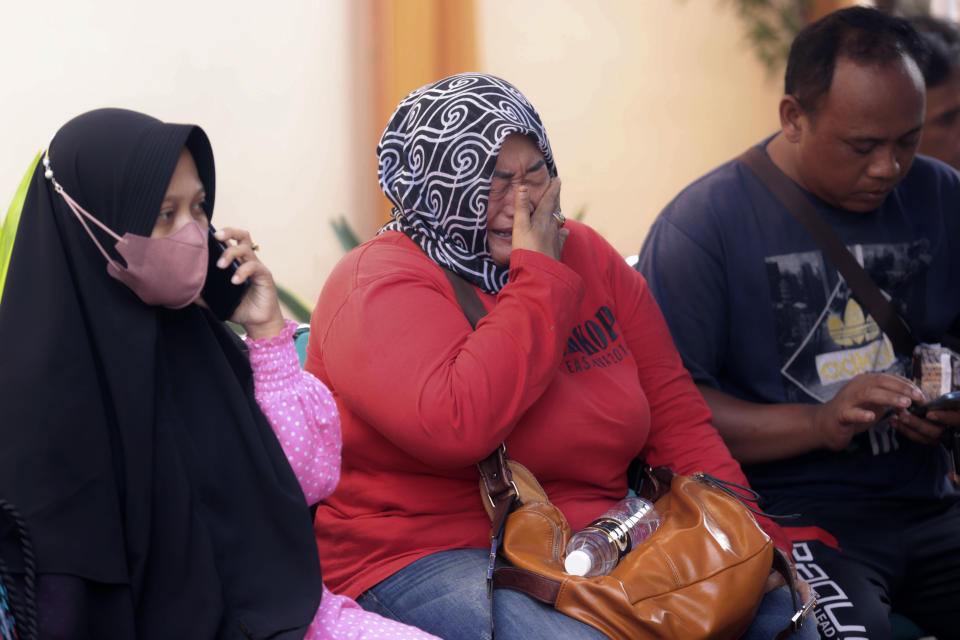 A relative of a victim in the soccer stampede cries as she waits at the Saiful Anwar Hospital in Malang, East Java, Indonesia, Sunday, Oct. 2, 2022. Panic at an Indonesian soccer match after police fired tear gas to to disperse supporters invading the pitch left over 100 people dead, mostly trampled to death, police said Sunday. (AP Photo/Trisnadi)