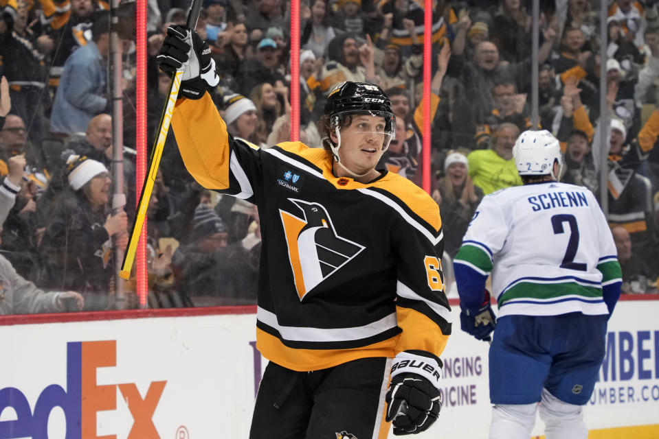 Pittsburgh Penguins' Rickard Rakell, left, celebrates his goal against the Vancouver Canucks during the second period of an NHL hockey game in Pittsburgh, Tuesday, Jan. 10, 2023. (AP Photo/Gene J. Puskar)