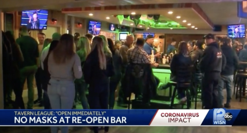 A news reel showing a packed Wisconsin bar. "No mask at re-open" it says. 