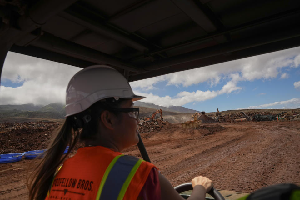 Kalewalani Bancaco, senior project manager for HomeAid Hawaii, drives through the temporary housing development Ka La'i Ola, which aims to house up to 1,500 wildfire survivors in 450 modular units over the next five years, Thursday, July 11, 2024, in Lahaina, Hawaii. The development will be located on 57 acres of land near the Lahaina Civic Center, overlooking parts of the burn zone. (AP Photo/Lindsey Wasson)