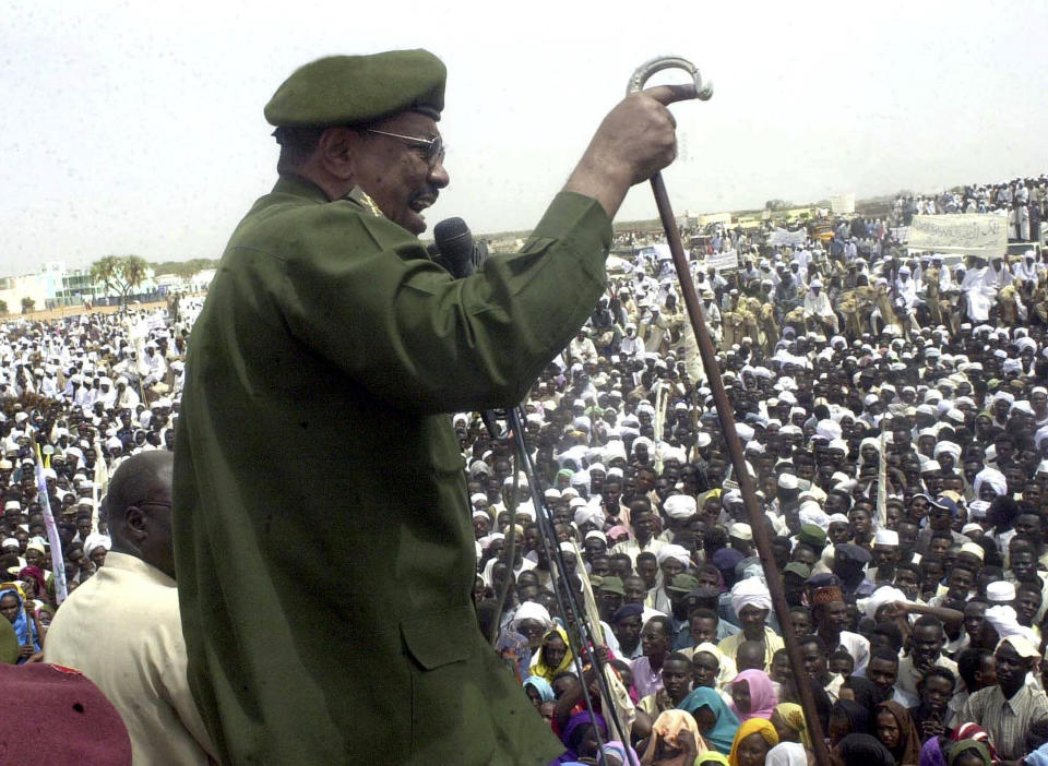 FILE - In this May 19, 2004 file photo, then Sudanese President Omar al-Bashir speaks to thousands of Sudanese in Nyala, capital of the country's southern Darfur state. Al-Bashir, driven from power in April 2019, and now languishing in a prison where his opponents were once jailed and tortured, is more vulnerable than ever to a decade-old international arrest warrant for war crimes committed in Darfur. But the military, which forced him from power after four months of mass protests, has said it will not extradite him to the International Criminal Court at the Hague. (AP Photo/Abd Raouf, File)