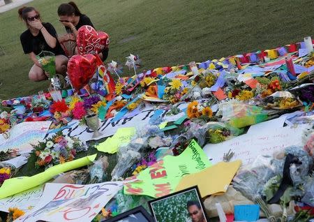 Two women cry as they visit a memorial for the victims of the shooting at the Pulse gay nightclub in Orlando, Florida, June 14, 2016. REUTERS/Jim Young