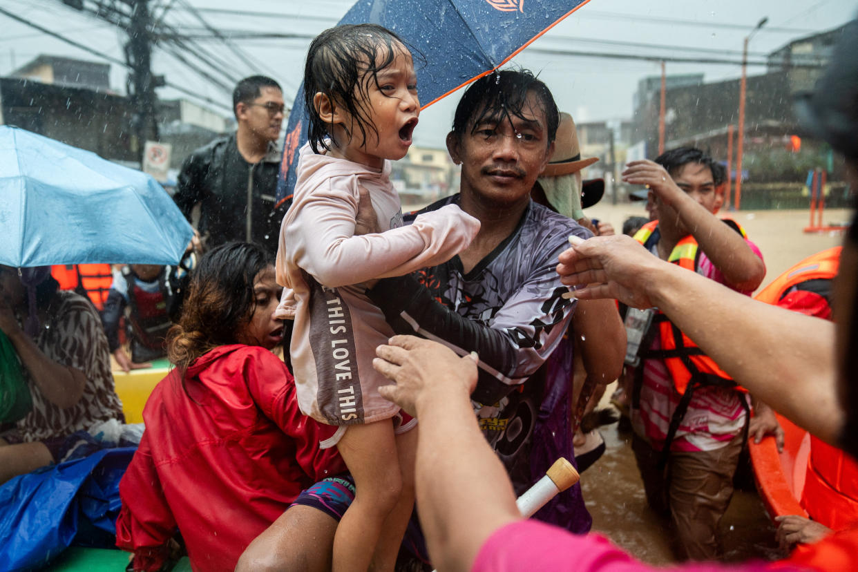 Rescuers help a child get off a boat along a flooded road following heavy rains brought by Typhoon Gaemi in the Philippines on July 24.