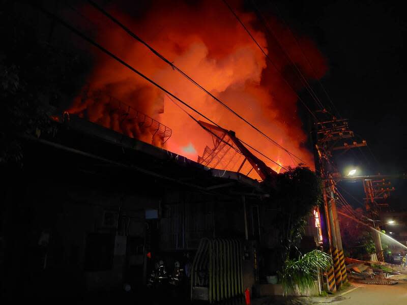 新北樹林鐵皮工廠起火（1） 新北市樹林區西圳街二段一處1層樓違章鐵皮工廠19 日晚間起火，現場堆放木材，全面燃燒，消防局獲報 出動人車到場馳援。 （翻攝照片） 中央社記者楊侃儒傳真  113年4月19日 