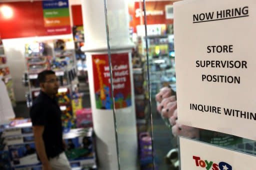 A "now hiring" sign is viewed in the window of a toy store in New York City. The US Federal Reserve took aim at slow growth and high joblessness, announcing a new, open-ended $40 billion per month bond-buying program as it slashed its 2012 growth forecast