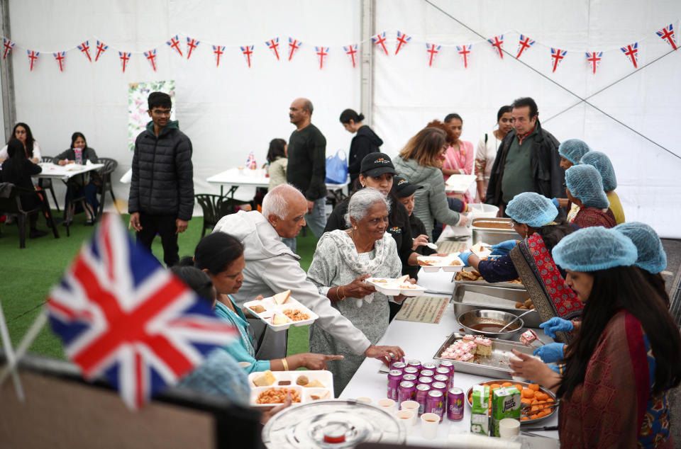 People are served food at a 'Big Lunch' event at the BAPS Shri Swaminarayan Mandir temple during celebrations following the coronation of King Charles and Queen Camillla, in London, Britain May 7, 2023. REUTERS/Henry Nicholls