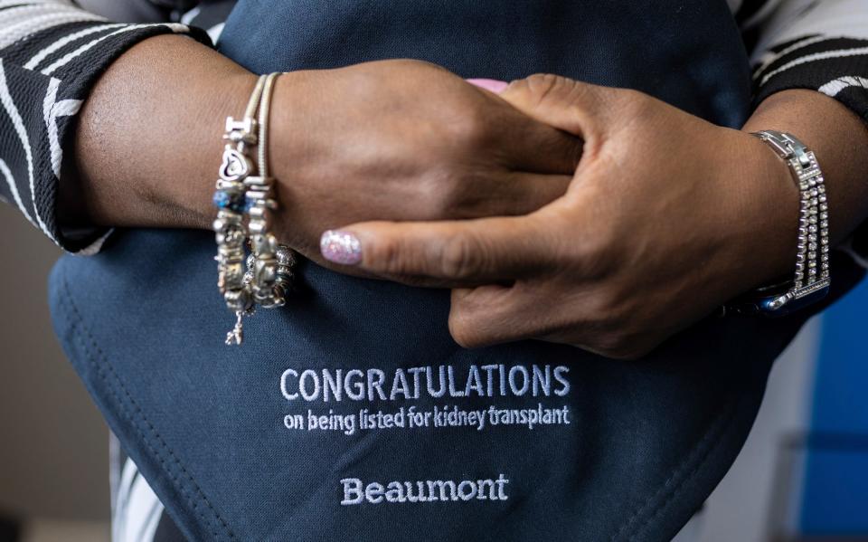 Iesha Morgan, a tax preparer and owner of Tax Stars LLC, holds a blanket from Beaumont congratulating her on making the kidney transplant waiting list as she stands inside Green Medical Supply LLC in Dearborn on Wednesday, March 20, 2024. Morgan has been waiting for a kidney transplant for more than four years.