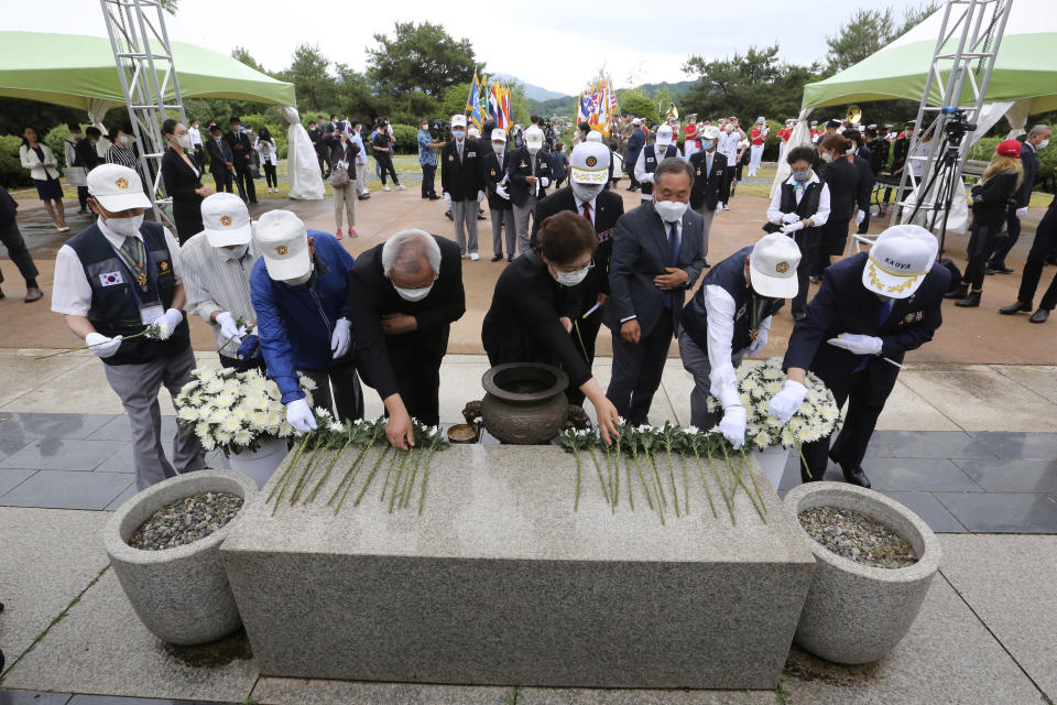 Korean War veterans, wearing white caps, and other participants place flowers to pay their respects during a ceremony to mark the 70th anniversary of the outbreak of the Korean War in Cheorwon, near the border with North Korea, South Korea, Thursday, June 25, 2020. The three-year Korean War broke out on June 25, 1950, when Soviet tank-led North Koreans invaded South Korea. (AP Photo/Ahn Young-joon)