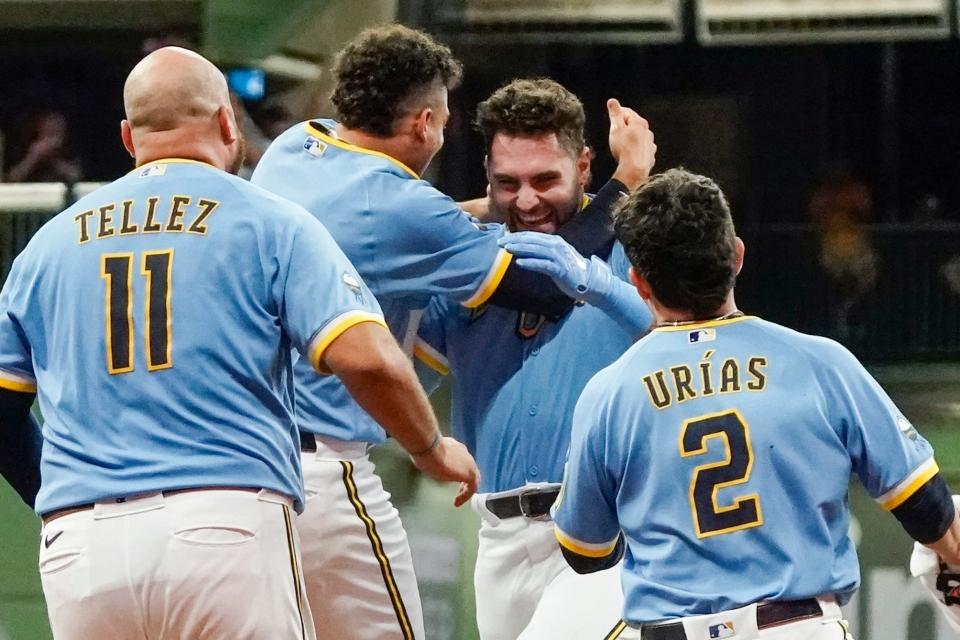 Garrett Mitchell is mobbed by his teammates after his two-out single in the ninth gave the Brewers a thrilling walk-off victory over the Yankees on Friday night.