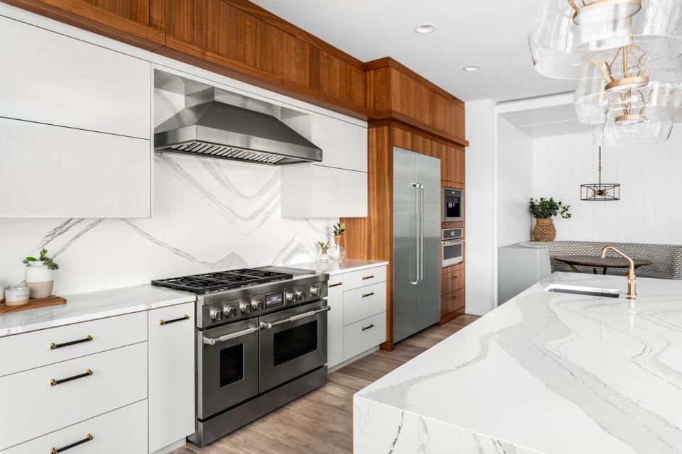 Large kitchen with white quartz countertops, a quartz kitchen island, and wood accent trim