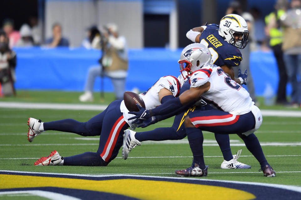 New England Patriots safety Adrian Phillips, right, intercepts a pass intended for Los Angeles Chargers running back Austin Ekeler (30) during the first half of an NFL football game Sunday, Oct. 31, 2021, in Inglewood, Calif. (AP Photo/John McCoy)