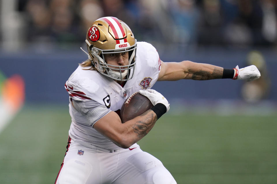 FILE - San Francisco 49ers tight end George Kittle carries the ball against the Seattle Seahawks during the first half of an NFL football game Dec. 5, 2021, in Seattle. No position in the NFL has undergone more changes to the style of player over the years than tight end. Long gone are the days of the blocking specialists who serve mainly as an extra offensive lineman. While guys like Rob Gronkowski, Travis Kelce and Kittle are excellent run-blockers, they are also outstanding receivers and major weapons on offense. (AP Photo/Elaine Thompson, File)