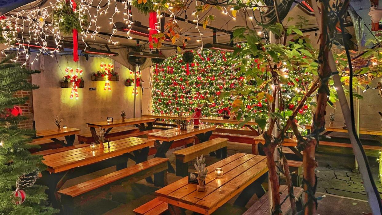 a room with tables and chairs and trees with lights