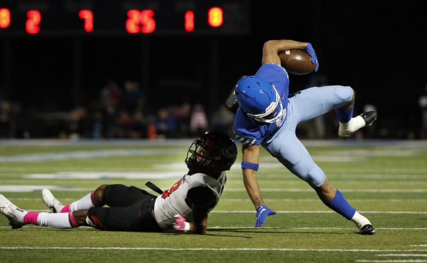 NORCO, CA - OCTOBER 15, 2021: Norco running back Jaydn Ott (8) tries to stay on his feet after being tackled by Corona Centennial defensive back Jaden Mickey (8) during the first half at Norco High School on October 15, 2021 in Norco, California.(Gina Ferazzi / Los Angeles Times)