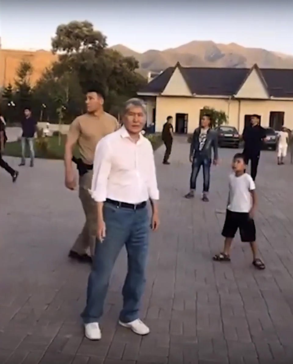 In this frame grab taken from Radio Free Europe/Radio Liberty footage, Former president of Kyrgyzstan Almazbek Atambayev stands at his residence in the village of Koi-Tash, about 20 kilometers (12 miles) south of the capital, Bishkek, Kyrgyzstan, Wednesday, Aug. 7, 2019. Special forces in the Central Asian country of Kyrgyzstan are raiding the residence of the former president, who faces corruption and abuse of office charges. There were conflicting reports on Wednesday evening on Almazbek Atambayev's whereabouts. (Radio Free Europe/Radio Liberty via AP)