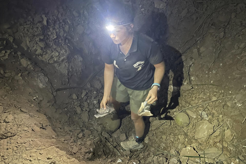 FILE - In this photo provided by the Free Burma Rangers, a man holds bomb shrapnel in a crater at a church in Lay Wah, one of the villages in Karen state's Mutraw district, Myanmar, Thursday, Jan. 12, 2023. Two years after seizing power, Myanmar's military continues to face stiff armed resistance on the ground, and is responding increasingly with air strikes that resistance forces have little defense against, says a report released Tuesday, Jan. 31, 2023, by a human rights monitoring group. (Free Burma Rangers via AP, File)