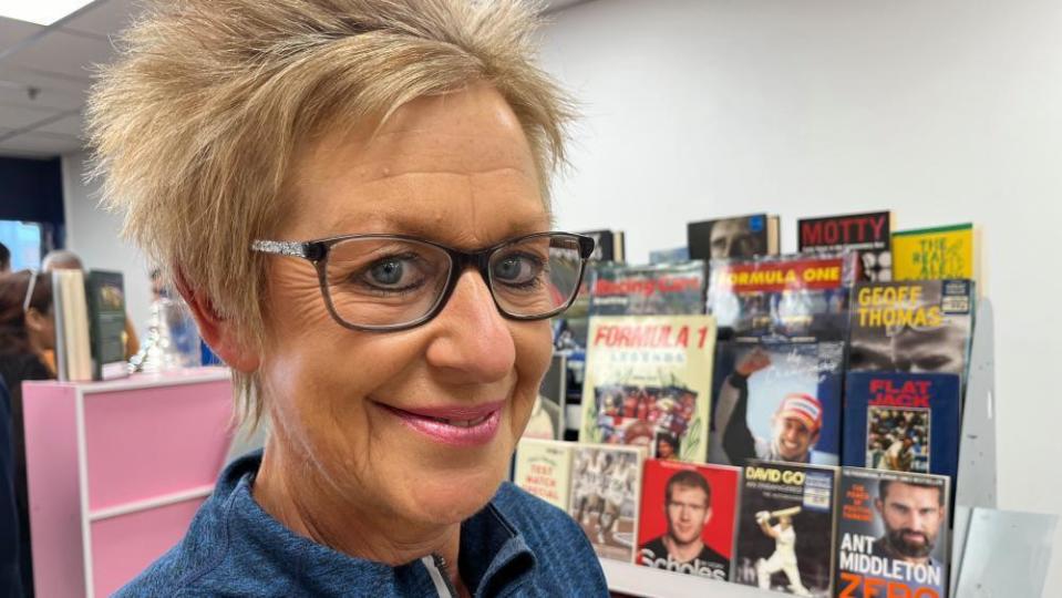 Karen Wright stands by a display of sports books