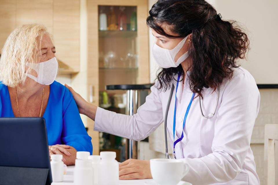 Serious young doctor touching shoulder of senior woman and reassuring her after prescribing medicine