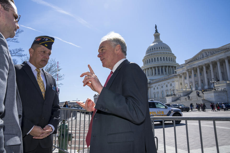 Sen. Tim Kaine, D-Va., right, talks to representatives of the American Legion before speaking to reporters about ending the authorization for use of military force enacted after the Sept. 11, 2001 terrorist attacks, at the Capitol in Washington, Thursday, March 16, 2023. Senators voted 68-27 Thursday to move forward with a bill to repeal the 2002 measure that authorized the March 2003 invasion of Iraq and a 1991 measure that sanctioned the U.S.-led Gulf War to expel Iraqi leader Saddam Hussein's forces from Kuwait. (AP Photo/J. Scott Applewhite)